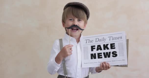 报童在混凝土墙的背景下大喊 卖假新闻的男孩穿着老式服装的孩子 小孩拿着报纸慢动作 — 图库视频影像