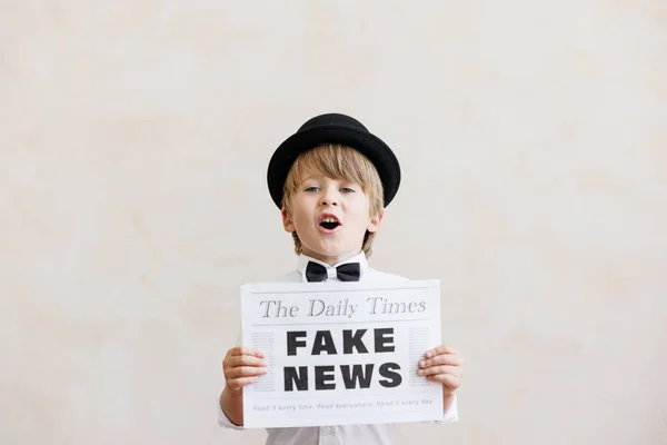 新聞の少年はグランジの壁の背景に叫んでいる 偽のニュースを売ってる ヴィンテージの衣装を着た子供 子供が新聞を持ってる ソーシャルメディアとインターネットネットワークの概念 — ストック写真