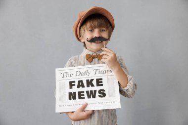 Newsboy shouting against grunge wall background. Boy selling fake news. Child wearing vintage costume. Kid holding newspaper. Social media and Internet nerwork concept clipart