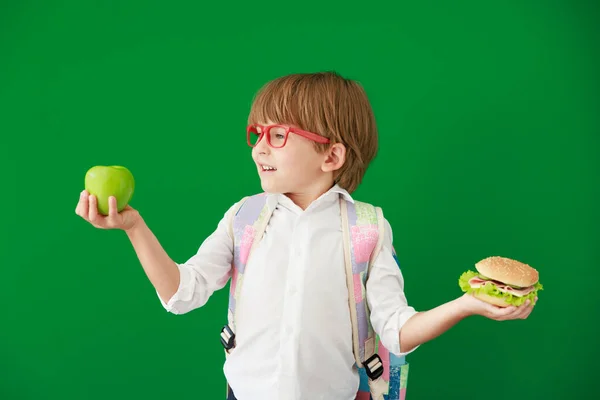 ハンバーガーとアップルをクラスで面白い子供の学生 緑の黒板に対して幸せな子供 教育と学校の概念に戻る — ストック写真