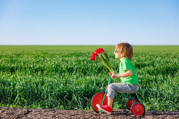 Šťastné Dítě Kole Venku Jarní Zelené Louce Dítě Držící Květiny — Stock fotografie