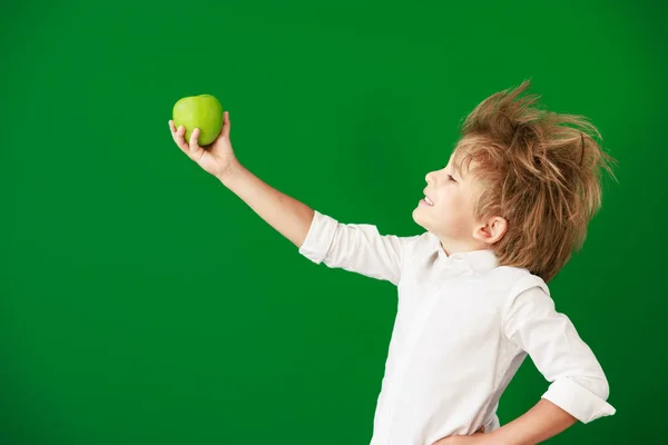 クラスでリンゴを持つ驚きの子供 緑の黒板を背景にした面白い子供 学校や教育の概念に戻る — ストック写真