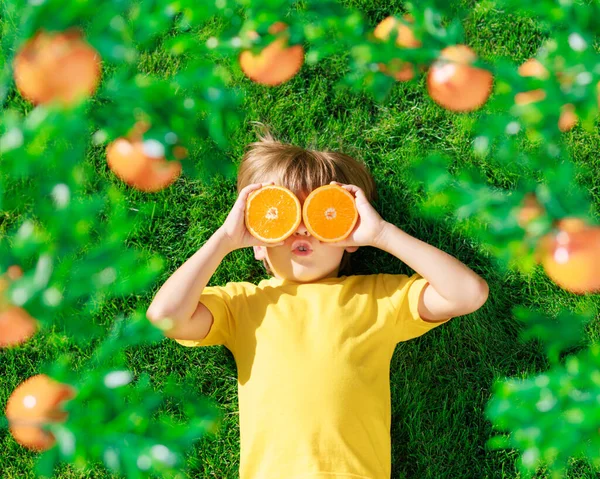 Überraschtes Kind Das Orangenscheiben Wie Sonnenbrillen Der Hand Hält Kind — Stockfoto