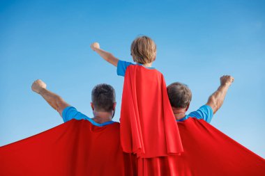 Kıdemli, erkek ve çocuk açık havada mavi gökyüzüne karşı. Büyükbaba, baba ve oğul süper kahraman gibi davranıyorlar. İnsanlar birlikte eğleniyor. Aile tatili konsepti. Babalar günün kutlu olsun.