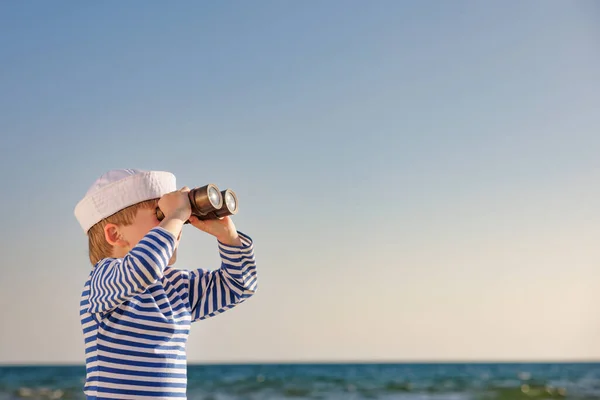快乐的孩子假装是水手 孩子长出了蓝色的大海和天空 男孩在暑假 小孩透过望远镜看 冒险和旅行概念 — 图库照片