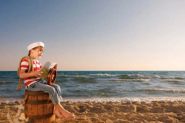 小孩假装是水手 小孩拿着地图小孩坐在海滩上的旧木桶上 男孩在暑假 冒险和旅行概念 — 图库照片