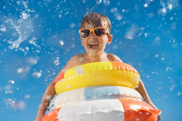 夏休みを楽しんでいる幸せな子供 プールに飛び込む面白い子供 水のスプラッシュに対する男の子の低角度ビューの肖像画 春休み — ストック写真