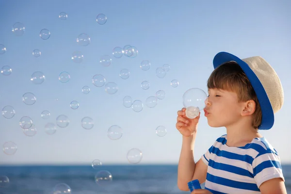 夏休みの幸せな子供 子供はビーチで楽しんでいます 石鹸泡を吹いている男の子 夏休みと旅行のコンセプト — ストック写真