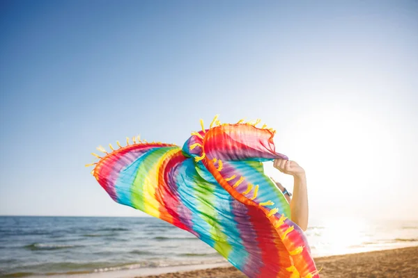 夏休みの幸せな女性 ビーチで虹の生地を保持する人 夏休みと旅行のコンセプト — ストック写真