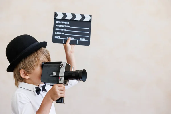 导演对着墙的后面大喊 男孩在家里玩 穿着老式服装的孩子 小孩拿着相机和拍手器社交媒体和因特网神经工作概念 — 图库照片