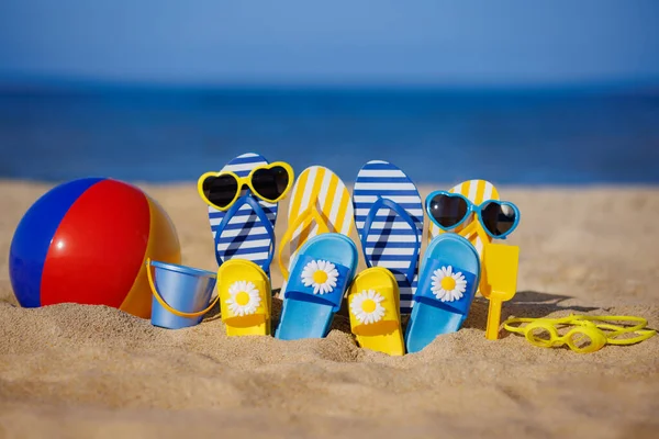 青い海の背景に黄色の砂の上に家族のフリップフロップ ビーチボール シュノーケリング 夏休みと旅行のコンセプト — ストック写真