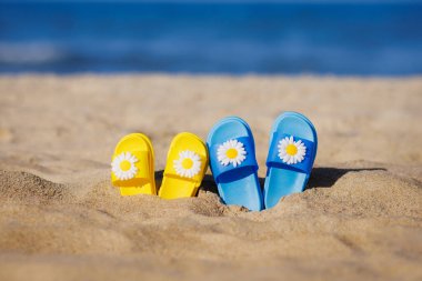 Sahilde mavi denizlere karşı terlik giyen çocuklar. Yaz tatili kavramı