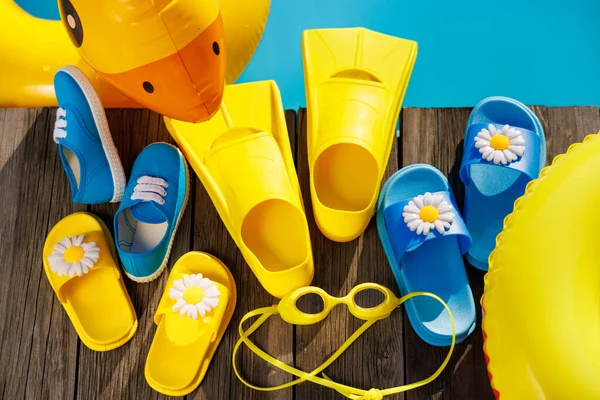 Strandteenslippers Zonnebrillen Houten Ondergrond Dingen Voor Vakantie Tegen Blauw Water — Stockfoto