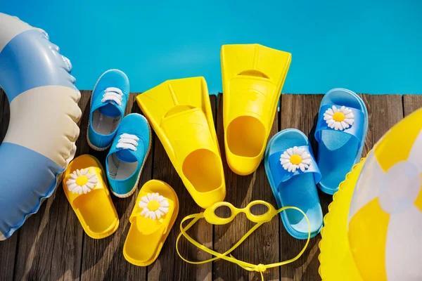 在木制背景上的海滩拖鞋和太阳镜 在游泳池蓝色水边度假用的东西 暑假和旅行概念 — 图库照片