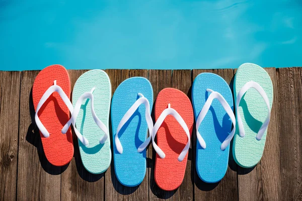 Chinelos Fundo Madeira Sapatos Praia Contra Água Azul Piscina Verão — Fotografia de Stock