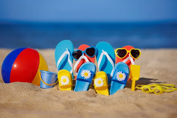 青い海の背景に黄色の砂の上に家族のフリップフロップ ビーチボール シュノーケリング 夏休みと旅行のコンセプト ストックフォト