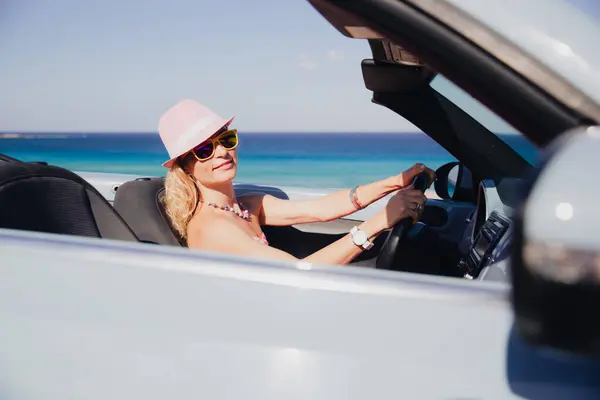 快乐的年轻女人在暑假开车旅行 在蓝色海附近的出租车里玩乐的人 暑假的概念 图库图片
