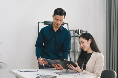 Modern ofiste iki iş arkadaşı yeni bir proje hakkında dostça tartışıyorlar.