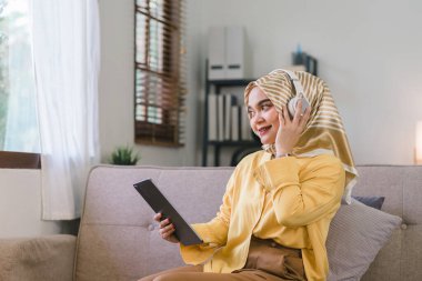 Mor tesettüre sahip Asyalı güzel bir iş kadınının portresi ev ofisinden uzaktan çalışıyor.