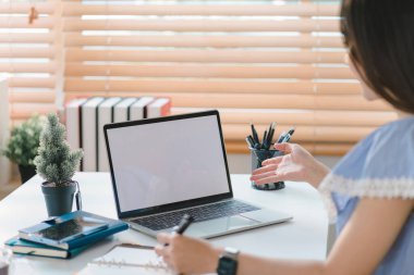 Ev ofisinin rahat bilgisayarında beyaz ekranda grafik montaj dizüstü bilgisayarı üzerinde çalışan bir kadının elleri yakın plan.