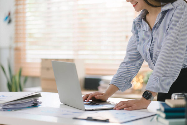 Close-up of hands of a female working on a laptop computer at her cozy home office
