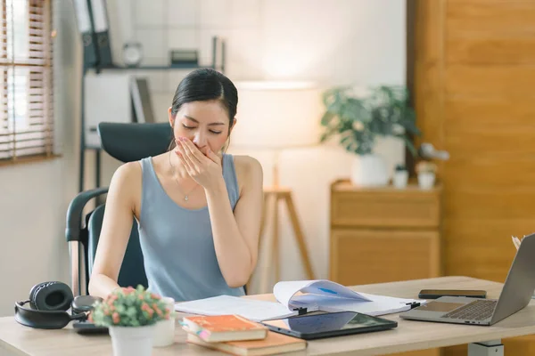 stock image While working from home, a stressed businesswoman appears to be overwhelmed, tired, and worried