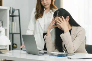 İki profesyonel Asyalı girişimci iş adamı bir konferans odasında değerlendirme verilerini tartışıyor, büyümeye odaklanıyor ve bir mali hesap grafiğine işaret ediyorlar,