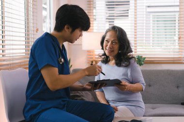 Genç Asyalı erkek hemşire, evde bakıcı destekli yaşam, ya da yaşlı bir vatandaşı ziyaret ederek sonuç takip listesi, sağlık hizmeti tavsiyesi veya reçeteli ilaç hakkında konuşmak