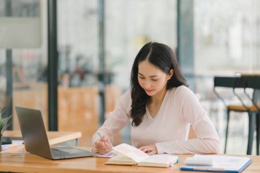 Genç, güzel, profesyonel ve kendine güvenen Asyalı bir iş kadınının portresi. Modern ofis içinde çalışıyor.