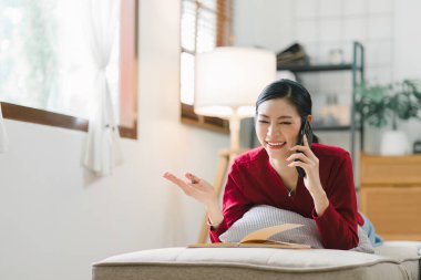 Evdeki rahat bir oturma odasında, güzel bir genç kadın kanepede uzanmış, akıllı telefonuna becerikli parmaklarıyla mesajlaşıyordu.