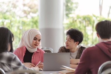 Bir grup farklı, çok ırklı Asyalı genç üniversite öğrencisinin bir toplantıda beyin fırtınası yaptığı ve tartıştığı görülüyor. Bu teknoloji ve takım çalışması kavramlarını tasvir eder.