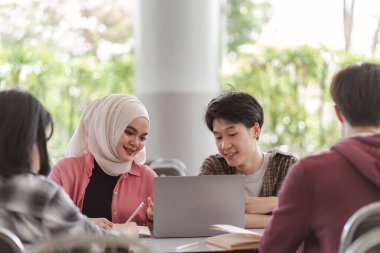 Bir grup farklı, çok ırklı Asyalı genç üniversite öğrencisinin bir toplantıda beyin fırtınası yaptığı ve tartıştığı görülüyor. Bu teknoloji ve takım çalışması kavramlarını tasvir eder.