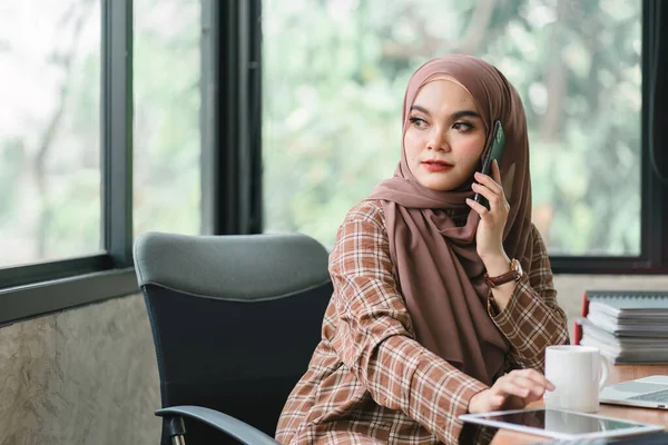 ヒジャーブを身に着けている美しいイスラム教徒のビジネス女性は 彼女のコンピュータで熱心に働いています 彼女の仕事にプロフェッショナリズムとコミットメントを表示します — ストック写真