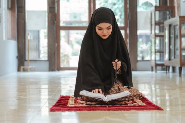 Müslüman bir kadının uzun bir tesettüre bürünmüş hali, İslam dini bir tören sırasında camideki Müslüman tanrıya dua edişini gösteriyor..