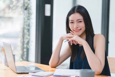 Profesyonel, güzel ve kendine güvenen bir kadının samimi bir kişiliği olan kapalı ofis geçmişine gülümseyen yakın plan portresi. Olumlu insan duyguları