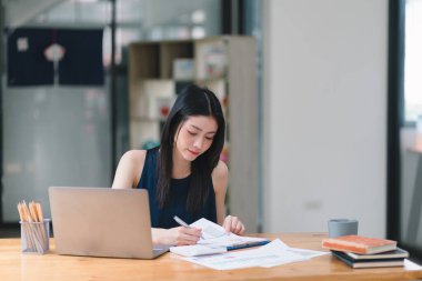 Bir iş kadını veya muhasebeci, mali yatırımlar, bir mali belge veri grafiğindeki iş ve pazarlama büyümesini analiz etmek için hesap makinesi kullanıyor