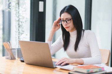 Profesyonel milenyum muhasebe kadını. Mali analiz belgeleri üzerinde çalışıyor. Ofiste gergin bir ifadeyle.