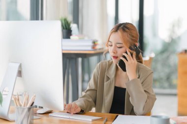 Bin yıllık mutlu Asyalı iş kadınının resmi günlük kıyafetlerle mali verileri incelerken iş görüşmesi yapıyor.