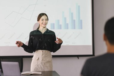 Genç iş kadını portresi pazarlama ve kazancı ofis, yatırım ve finans planlama semineriyle sunar, iş kadını ayakta duran grafiği ve grafiği açıklar