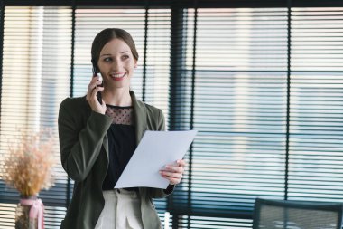 Bin yıllık mutlu iş kadınının gündelik giysiler içindeki yakın plan resmi finansal verileri analiz ederken iş görüşmesi yapıyor.