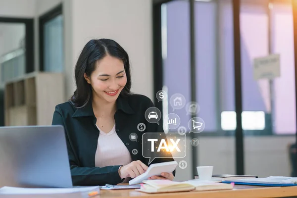 Businesswoman using laptop for online income tax return form. Symbolic of financial research, government taxes, and tax return calculation. Also alludes to tax and VAT concepts
