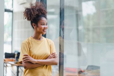 Dost canlısı, neşeli ve çekici afro saçlı, elleri göğsünün üzerinde duran Afrikalı Amerikalı kadın.