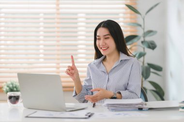 Neşeli bir iş kadını, mutfaktaki masasında web konferansı düzenlerken evden uzakta çalışıyor.