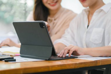 İki işadamı veya bir muhasebeci, istatistiksel bir rapor hazırlamak ve mali verileri bir ofiste tartışmak için dizüstü bilgisayardaki veri tablolarını, grafikleri ve gösterge panelini analiz ediyor.