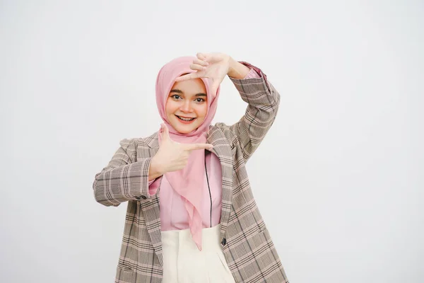 美しい若いイスラム教徒の女性ピンクヒジャブのスタジオ肖像画は 白い背景に彼女の指を指差すカメラで微笑みます — ストック写真