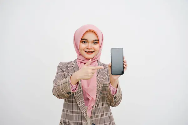 美しい若いイスラム教徒の実業家ピンクヒジャブの肖像画は 白い背景に隔離された携帯電話を示し 示しています スマートフォン広告用コンセプト — ストック写真