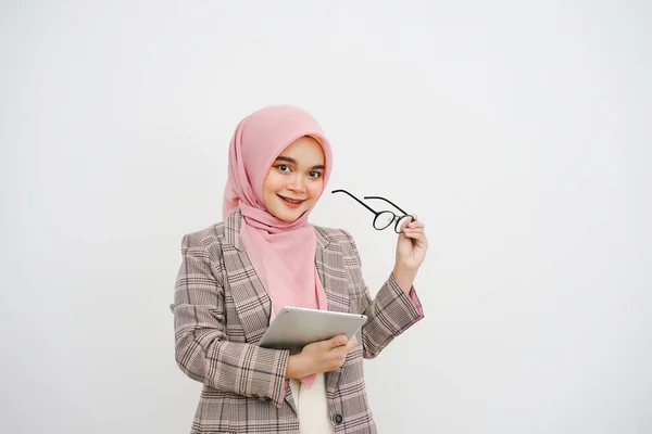 幸せな美しい若いイスラム教徒の実業家ピンクヒジャブの肖像画 メガネの会社の労働者 笑顔とホールドデジタルタブレット 白い背景の上に立って — ストック写真