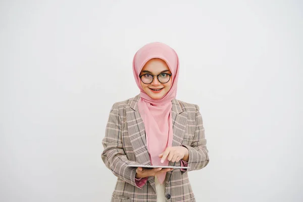 幸せな美しい若いイスラム教徒のビジネスマンピンクヒジャブ メガネの会社の労働者 笑顔とホールドデジタルタブレット 白い背景の上に立って — ストック写真