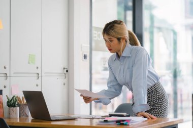 Finansal analist veya muhasebeci, yatırım projesini planlamak için dijital bir dizüstü bilgisayardaki iş mali raporlarını analiz eder