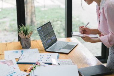 Finansal analist veya muhasebeci, yatırım projesini planlamak için dijital bir dizüstü bilgisayardaki iş mali raporlarını analiz eder